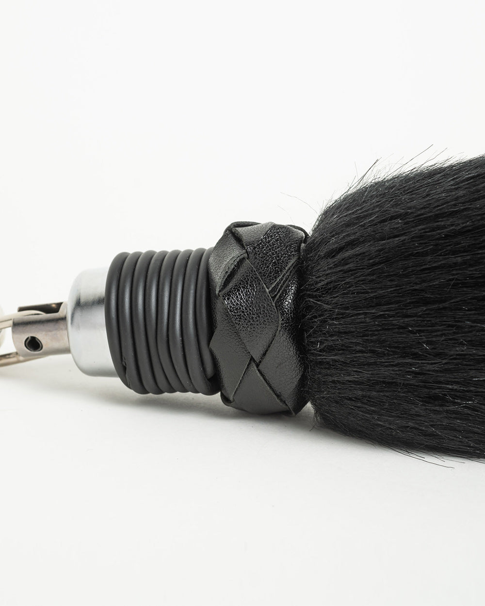 Black foxtail close up with braided handle on a white background