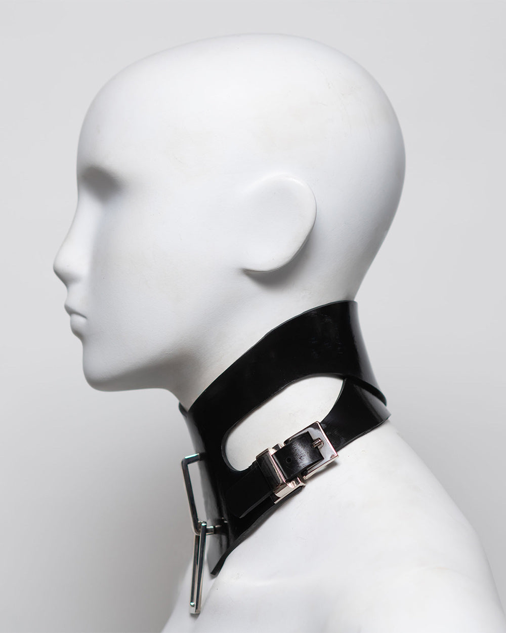 Black leather choker with metal buckle on a mannequin head against a white background