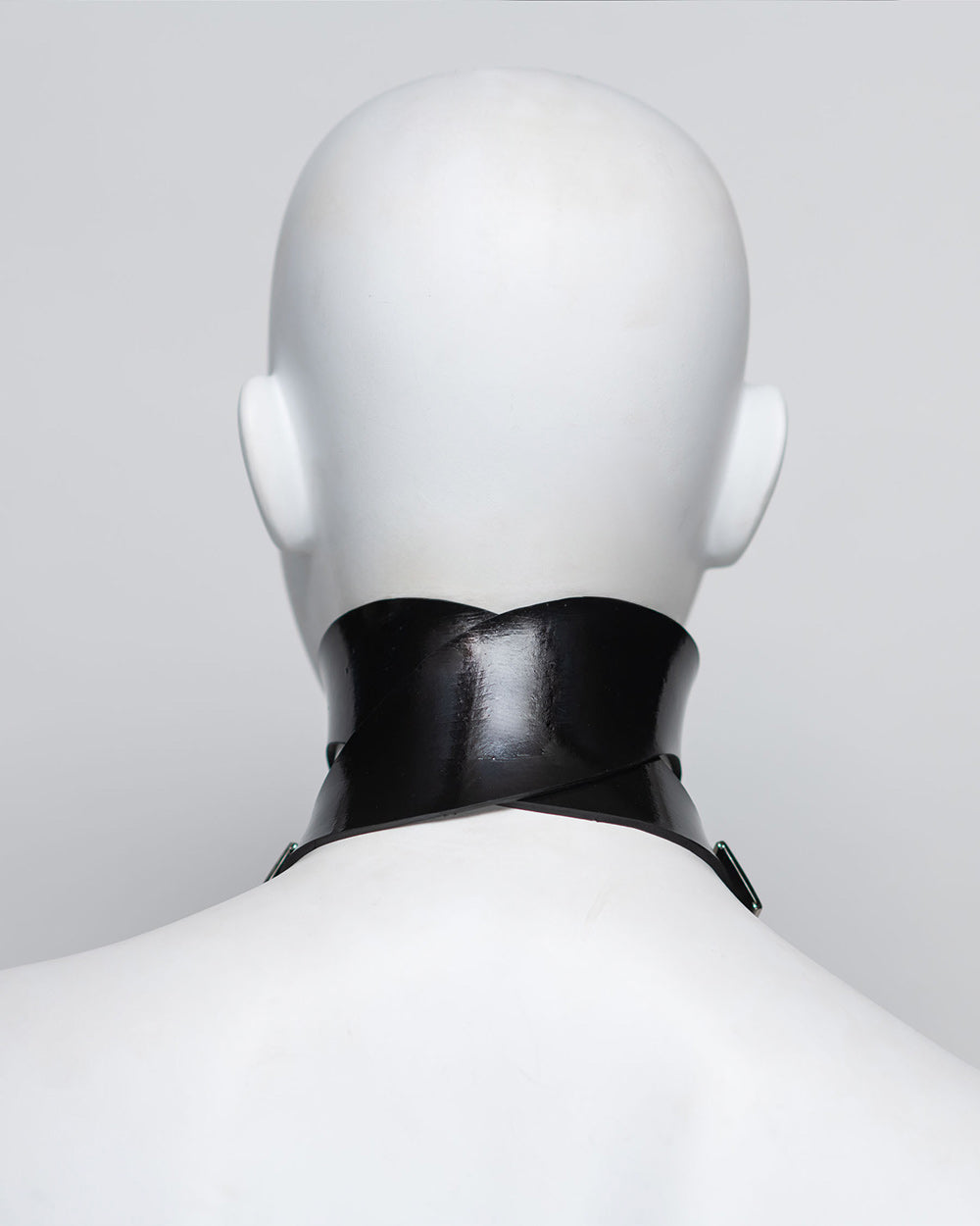 Mannequin wearing a black rubber choker against a light gray background
