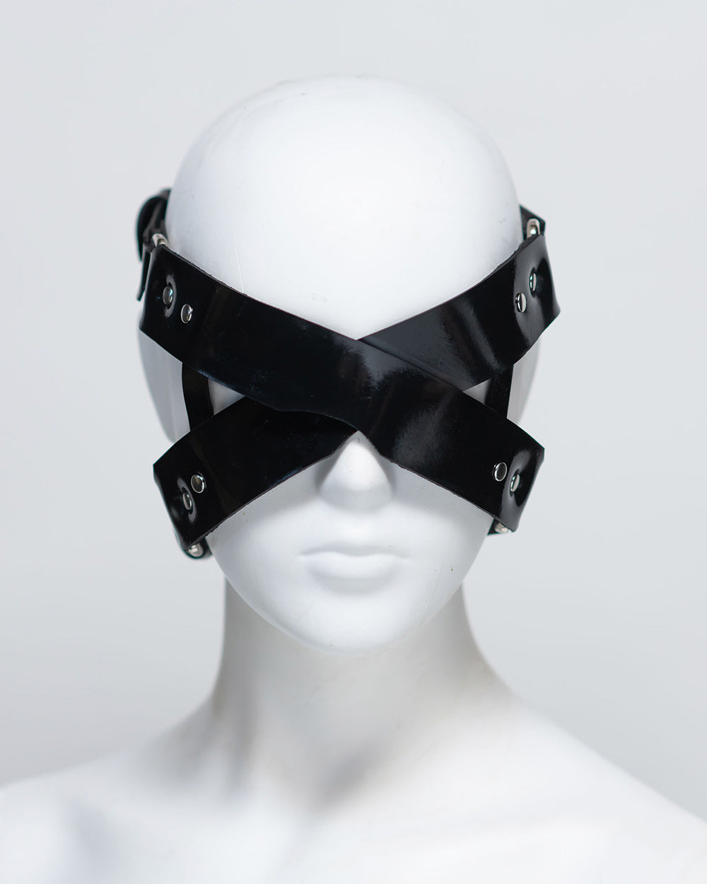 The front of the zafira cross padded blindfold is shown on a white mannequin in front of a white background. 
