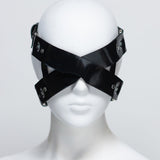 The front of the zafira cross padded blindfold is shown on a white mannequin in front of a white background. 