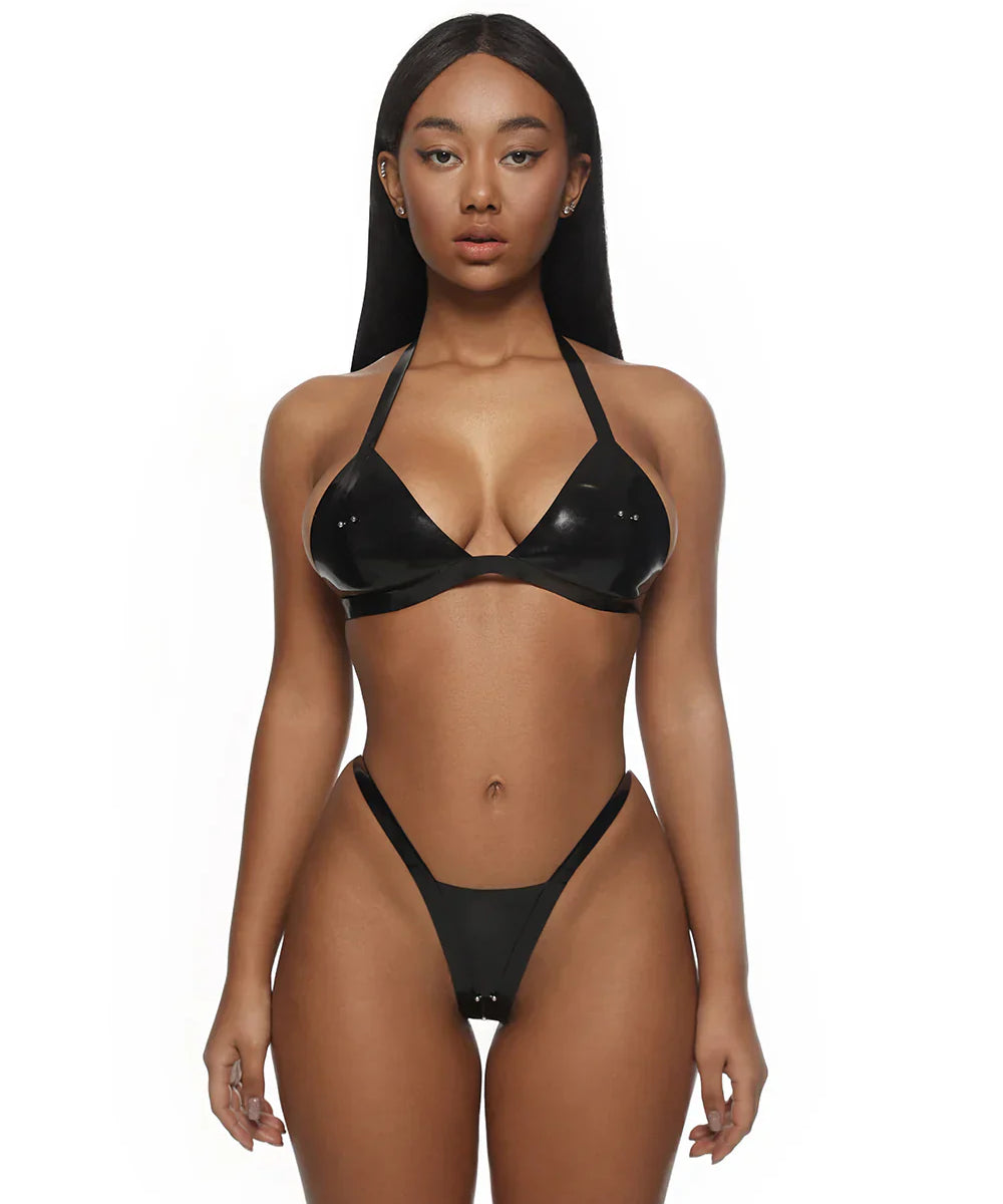 Woman wearing a black latex bikini on a white background