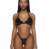Woman wearing a black latex bikini on a white background