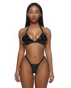 Woman wearing a black latex bikini on a white background