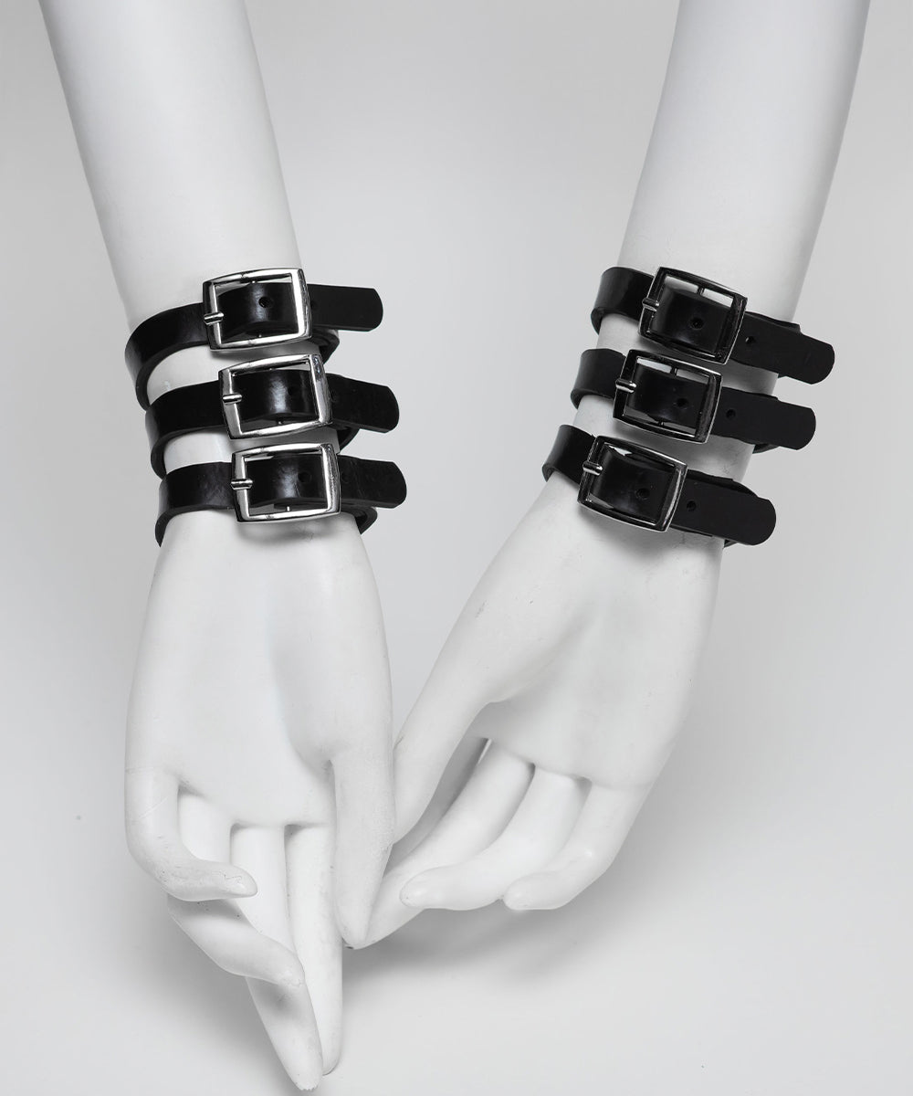 Black rubber bracelets with buckles on white mannequin hands against a light gray background