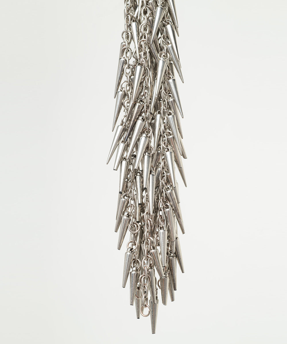 Silver spike and chain flogger close up on a light gray background