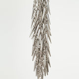 Silver spike and chain flogger close up on a light gray background