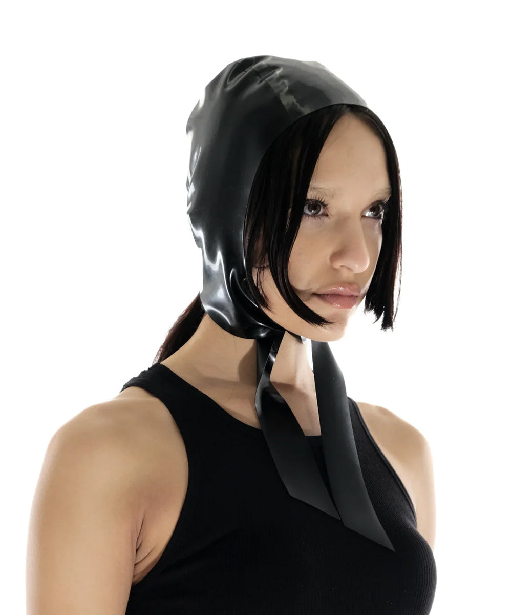 A brunette model is shown wearing the black latex bonnet against a white background.