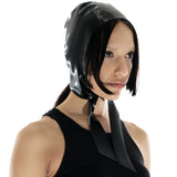 A brunette model is shown wearing the black latex bonnet against a white background.