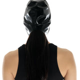 A brunette model is shown from the back wearing the black latex bonnet against a white background.