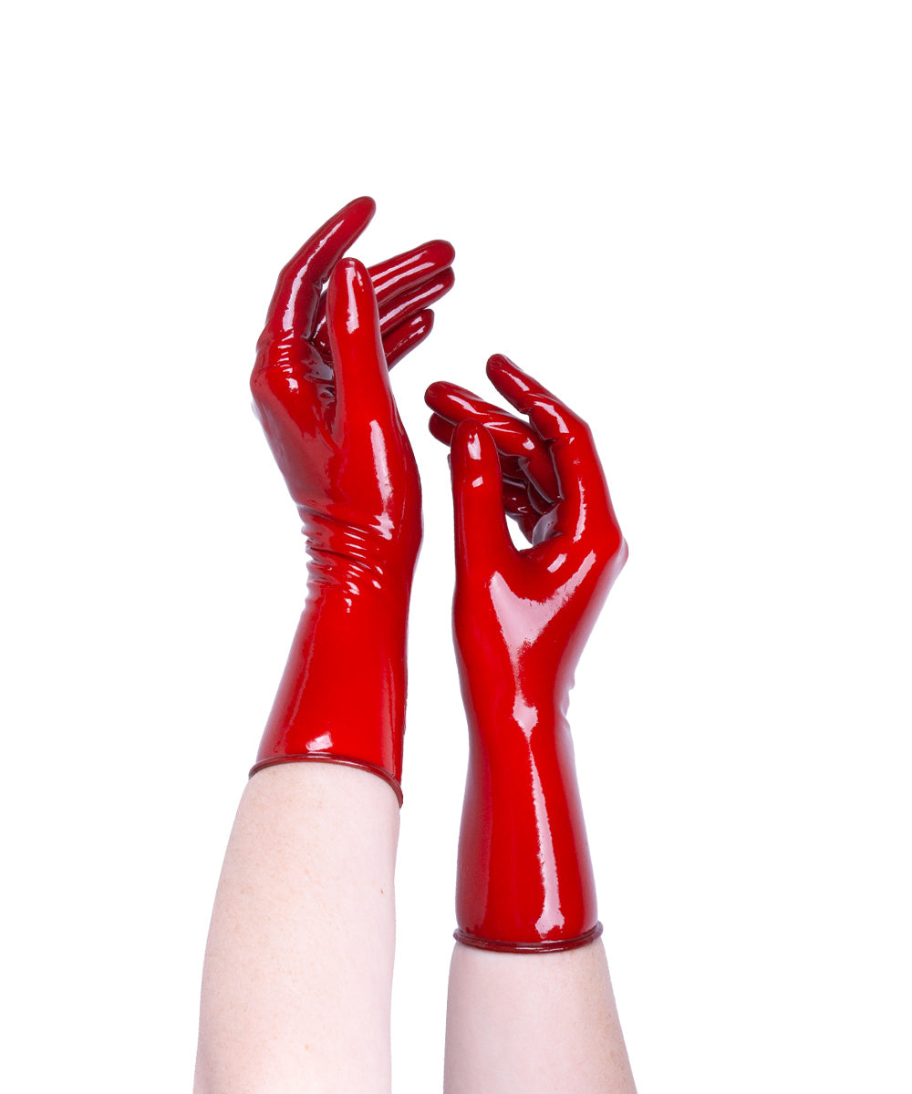 Red glossy gloves worn on a white background