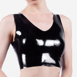Person wearing a black latex crop top on a white background