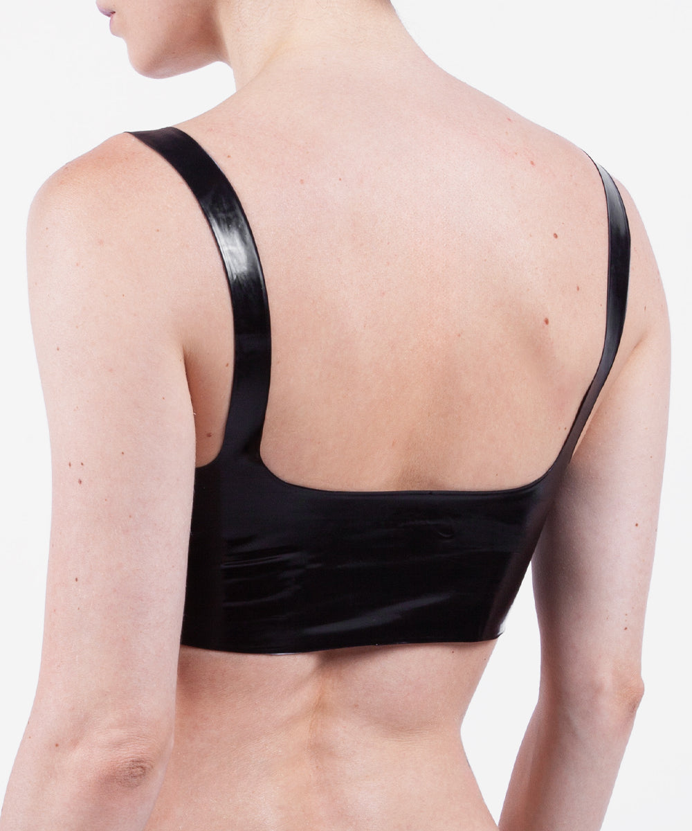The back of a model is shown wearing a glossy latex basic halter bra, standing in front of a white background.