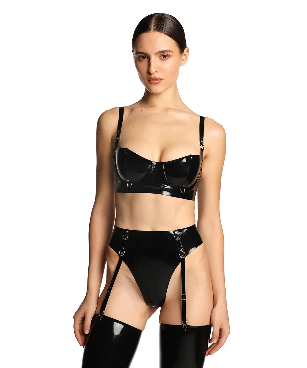 A close-up of a model wearing the black grip latex bra is shown in front of a white background.