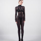 Model wearing a black bodysuit with sheer panels on a white background