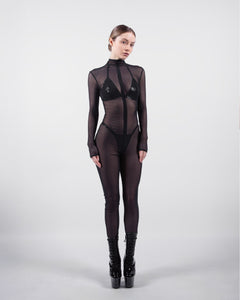 Model wearing a black bodysuit with sheer panels on a white background
