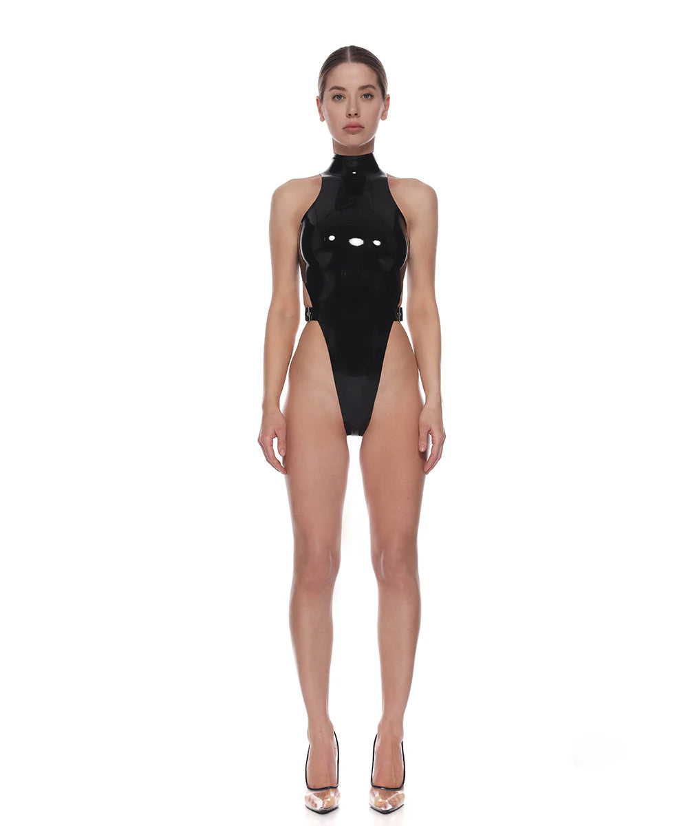 A model is shown wearing the black stella010 latex bodysuit in front of a white background. 
