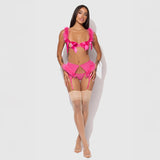 Model wearing a pink lingerie set with bows on a white background