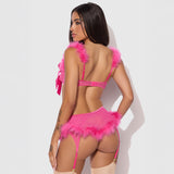 Woman wearing a pink lingerie set with feather details on a white background