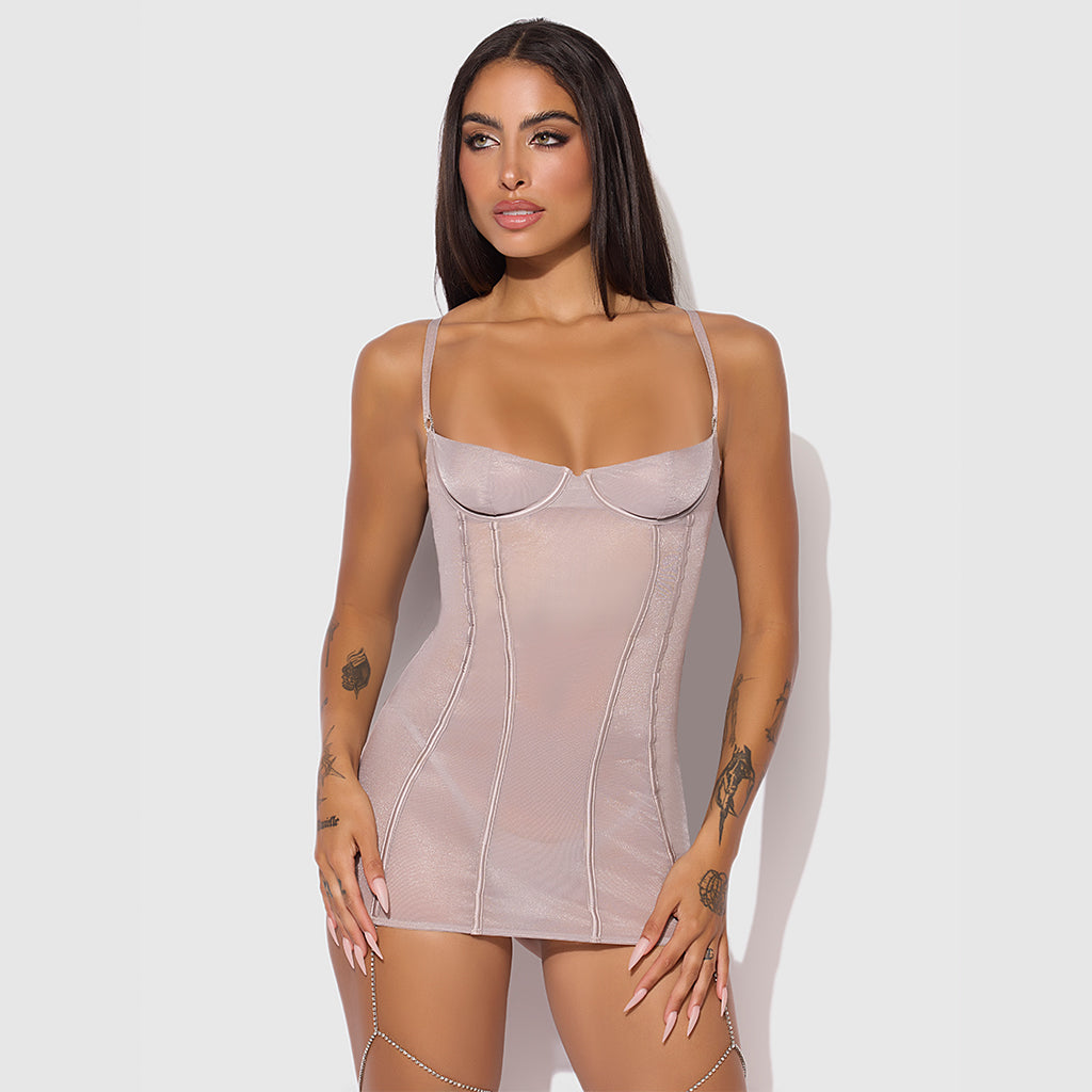 Woman wearing a beige shapewear dress against a white background