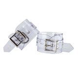 The Clear CTRL Clear Vinyl Wrist Cuffs are shown from the back against a blank background. The cuffs are completely transparent with metal hardware. They each have a lockable buckle with an adjustable strap and a D-ring.