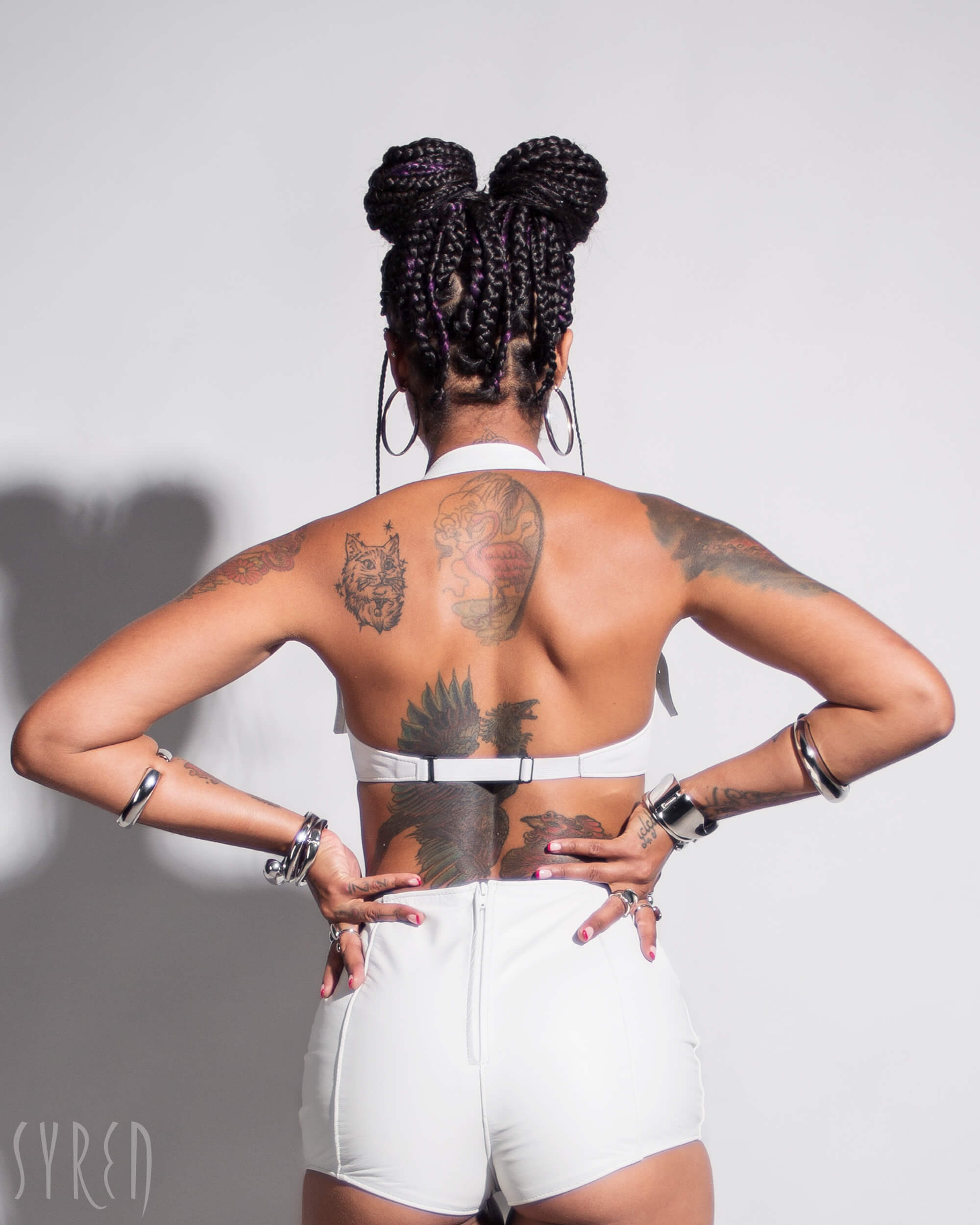A back close-up of a model wearing the Stormy Leather Showgirl bra against a light gray background.
