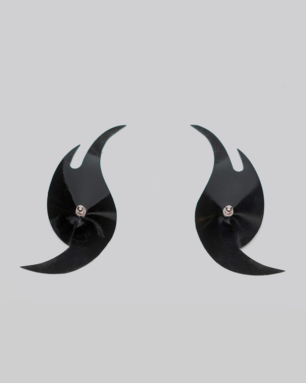 Pair of black crescent-shaped pasties on a light gray background
