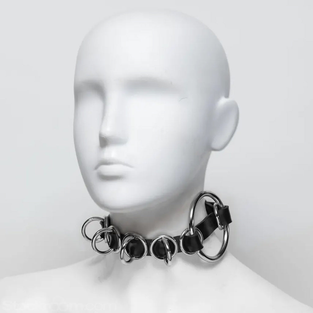 Mannequin head wearing a black chain collar on a white background