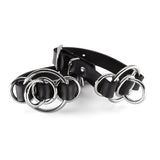 Black leather cuffs with silver rings on a white background