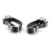 Two black leather cuffs with metal buckles on a white background