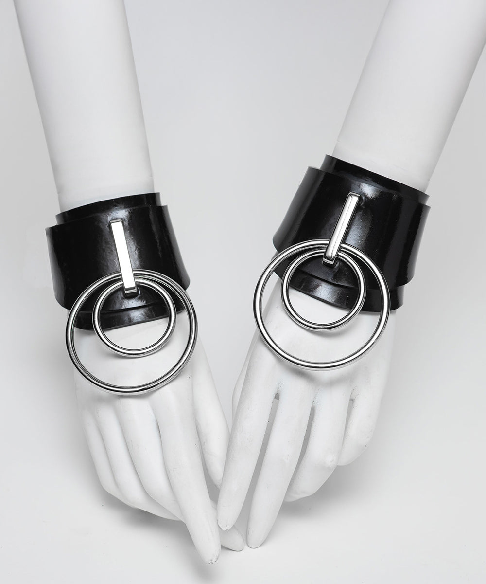 Ilaria double O ring wrist cuffs on white hands against a white background. 