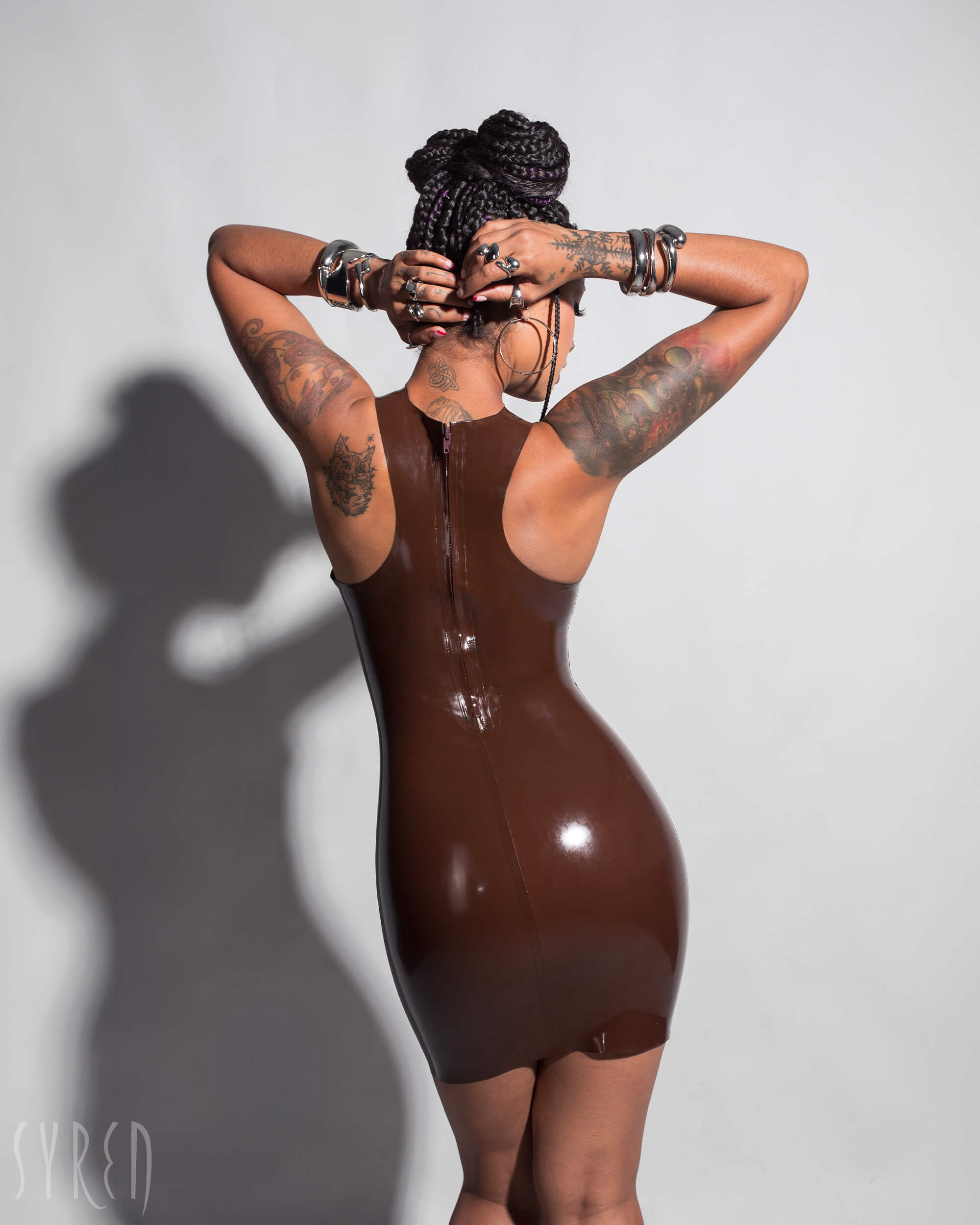 A close-up of a model is shown from the back wearing the Syren cocoa racer front dress