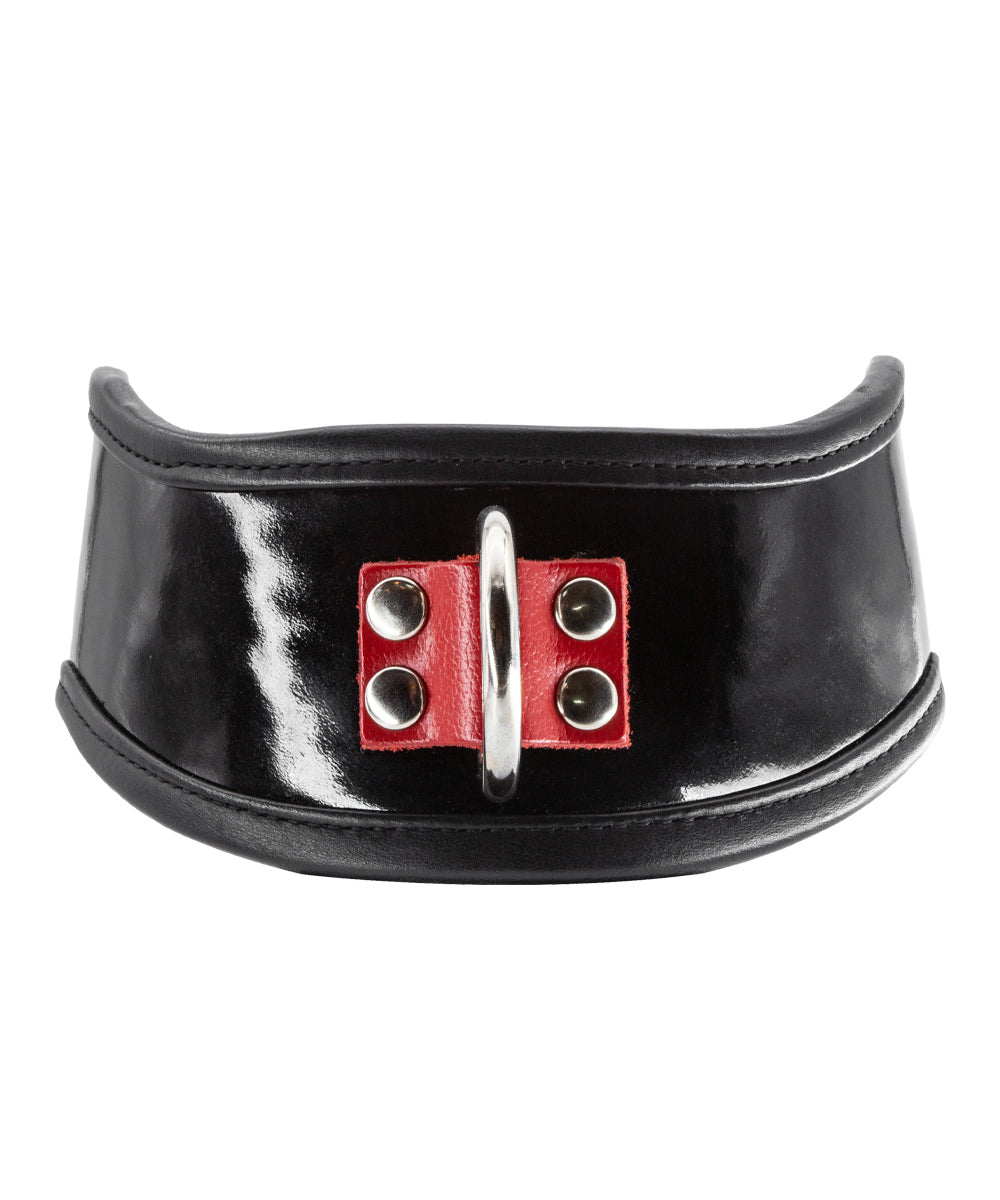The Firecracker Patent Leather Posture Collar is shown against a blank background. The collar is patent leather with matte black leather lining. A piece of red leather secures a metal D-ring in the front.