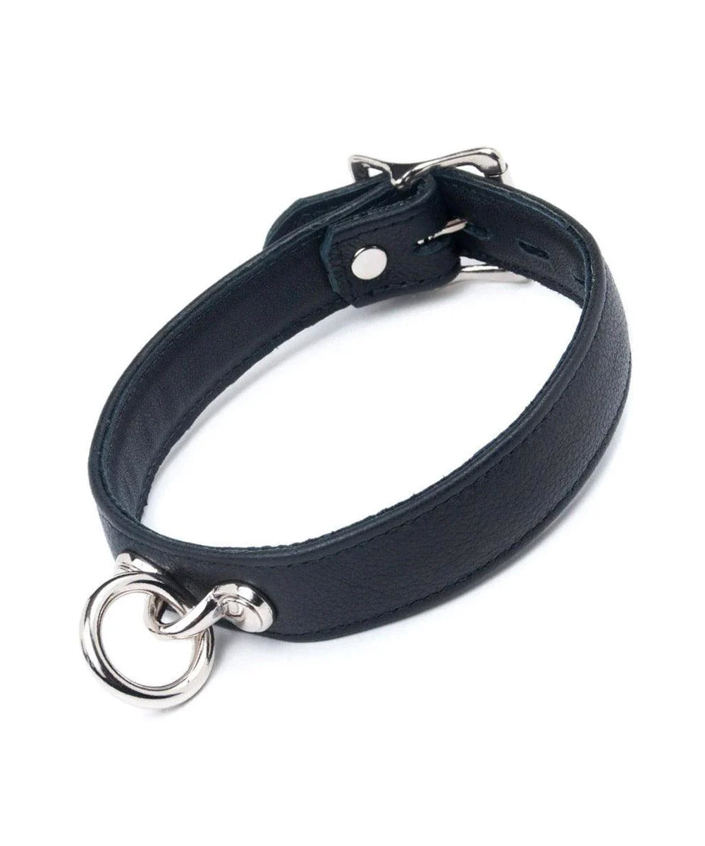 The Premium Garment Leather Collar in black is shown against a blank background. The collar is made of black leather and has silver hardware. It has a dangling O-ring in the front and a buckle fastener in the back.