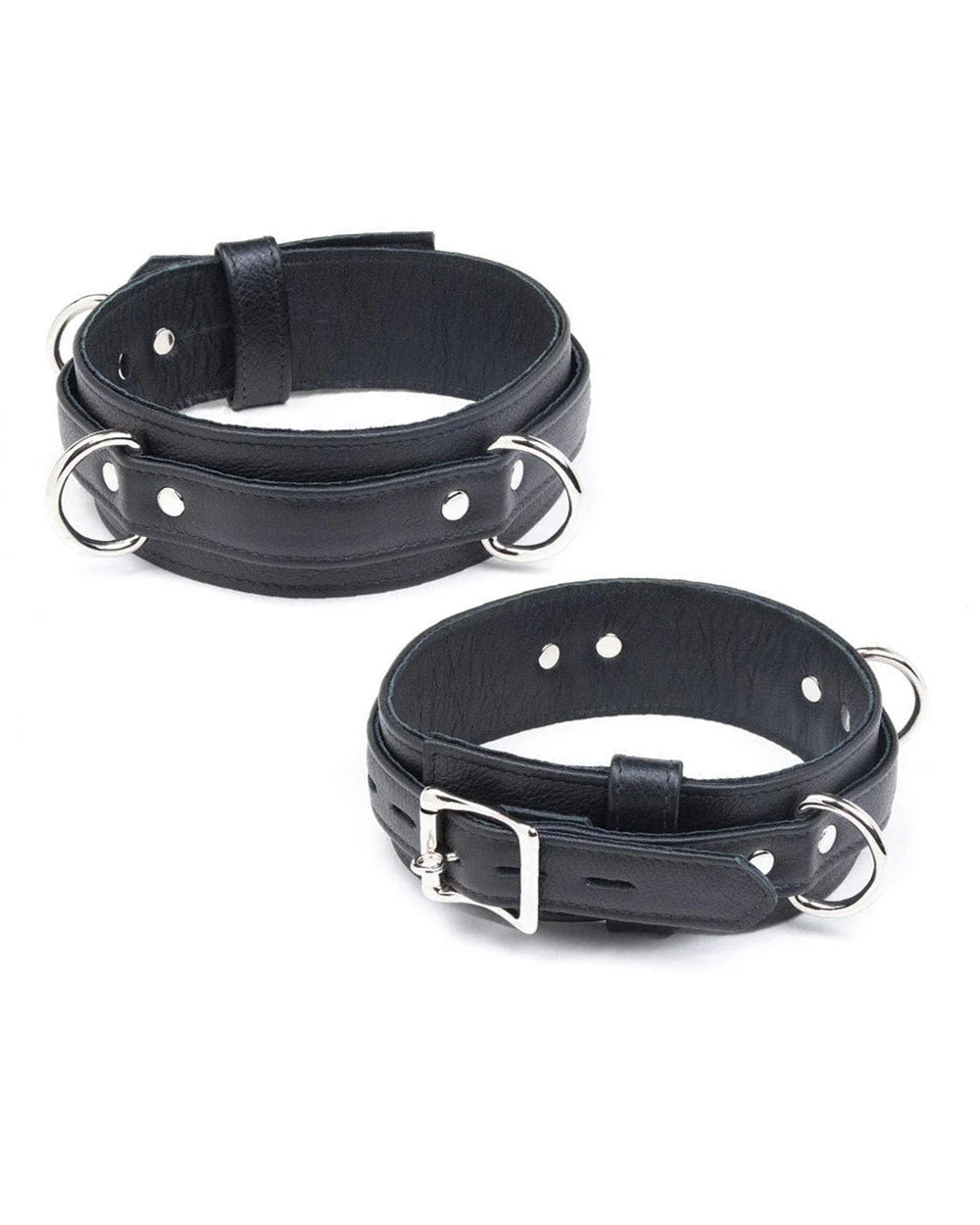 The Premium Garment Leather Locking Thigh Restraint set in black is displayed against a blank background. It is a thick band of black leather with silver metal hardware. The cuff has three evenly spaced D-rings.