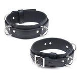 The Premium Garment Leather Locking Thigh Restraint set in black is displayed against a blank background. It is a thick band of black leather with silver metal hardware. The cuff has three evenly spaced D-rings.