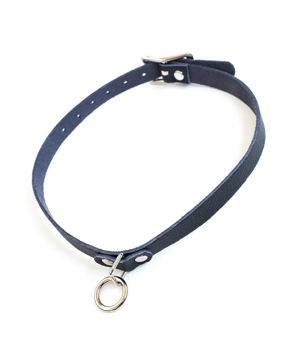 The Vondage Choker With O-Ring is shown against a blank background. It is made of a thin piece of black vegan leather and metal hardware.
