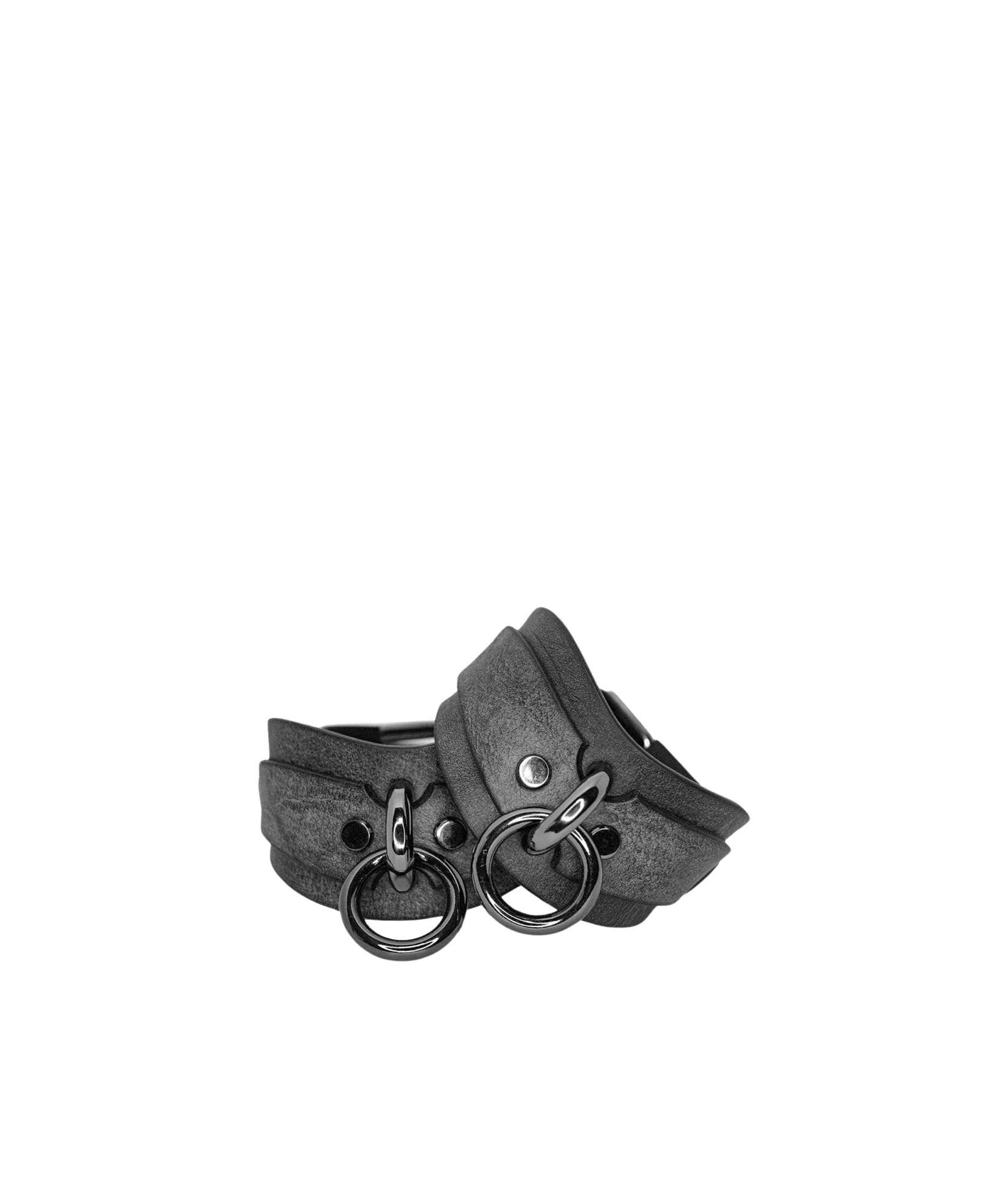 Gray leather cuffs with metal rings on a white background
