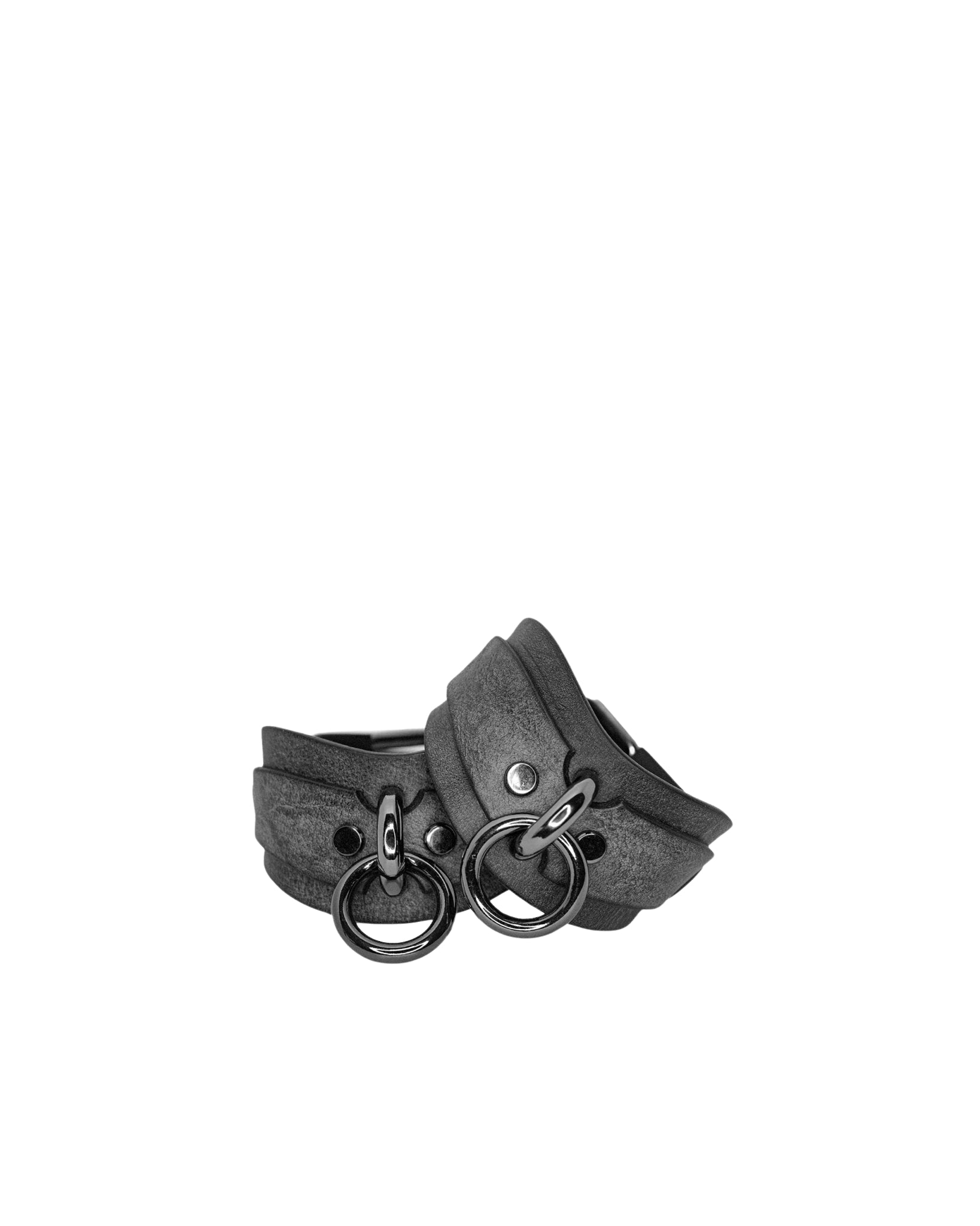 Gray leather cuffs with metal rings on a white background