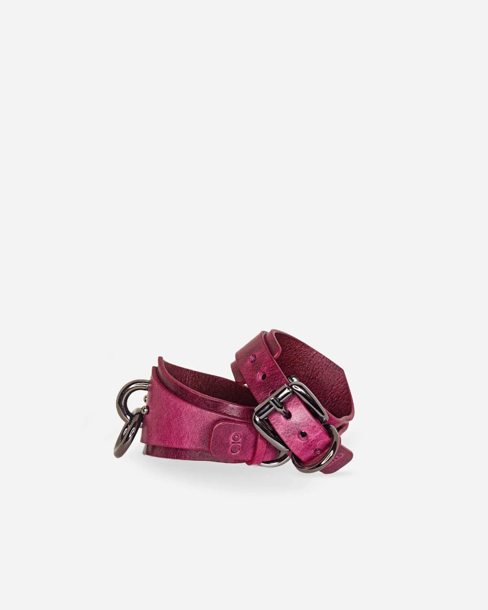 Pink leather wirst cuffs with metal buckle on a white background