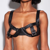 Black leather bra with buckles worn by a model against a neutral background